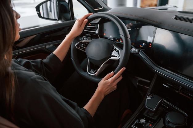 テストドライブのコンセプト 美しいビジネスウーマンが新しい車に乗っています