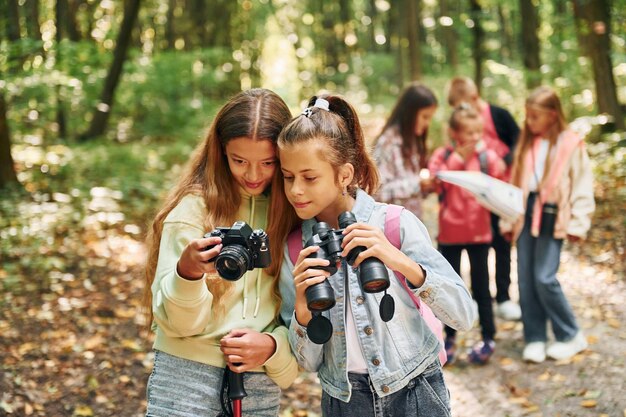 Photo conception of tourism kids in green forest at summer daytime together