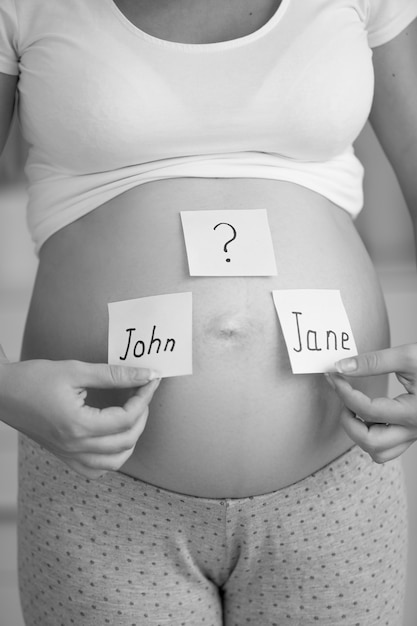 Conceptual black and white photo of pregnant woman thinking of future baby gender and name