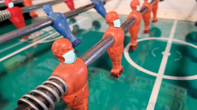 Conceptual covid image table soccer player wearing masks to protect from coronavirus Covid 19 pandemic