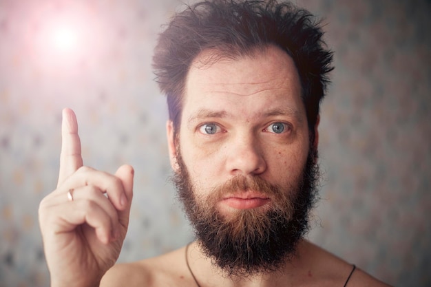 The conceptual idea of a Caucasian man with a beard shows index finger up