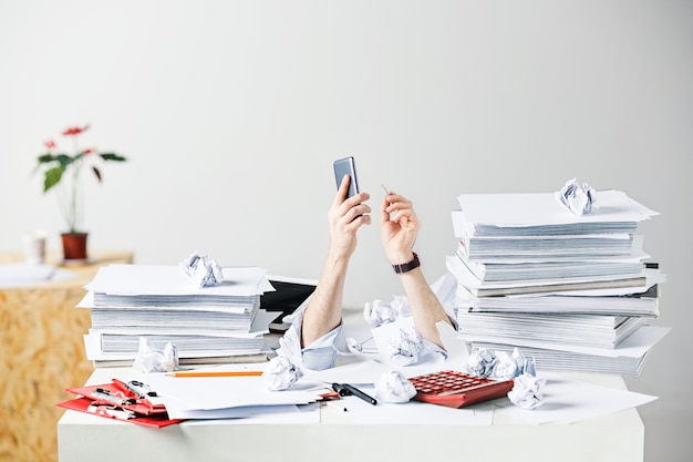 The conceptual image or collage about many of crumpled papers on the desk of stressed male workplace