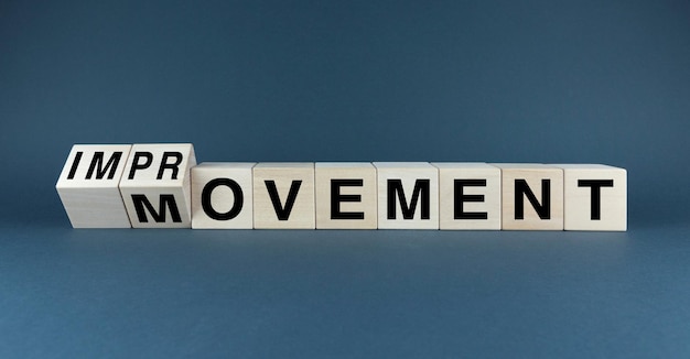 Концептуальное изображение с деревянными блоками, обозначающими IMPROVEMENT и MOVEMENT