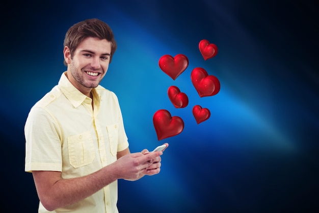 디지털 생성된 빨간 하트와 함께 휴대 전화로 문자 메시지를 보내는 남자의 개념적 이미지