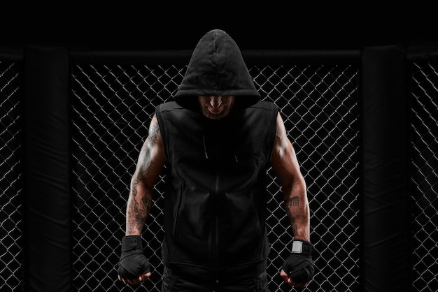 写真 キックボクサーの概念画像 - オクタゴンの本物のケージに立っている本物のファイター - 混合武術キックボクシングスポーツ学校の概念 - 混合メディア