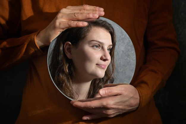 Foto madre concettuale che tiene uno specchio e il riflesso della figlia