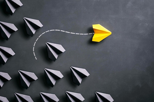 Conceptual photography with black and yellow paper airplanes on