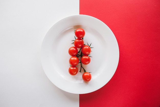 Conceptual picture of fresh cherry tomatoes on plate healthy ripe vegetables on contrast white and