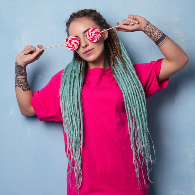 Conceptual portrait of woman with tattoos and dreadlocks