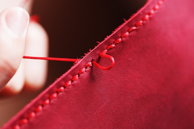 Conceptual profession of a Tanner. The woman's hands closed around the needle and thread.