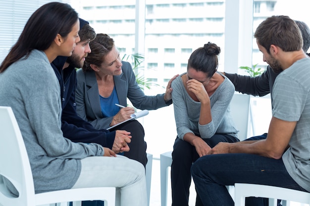 Concerned patients comforting another in rehab group