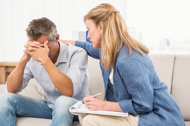 Concerned therapist comforting male patient