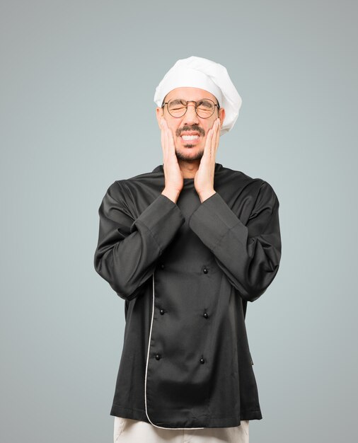 Concerned young chef doing a gesture of relief