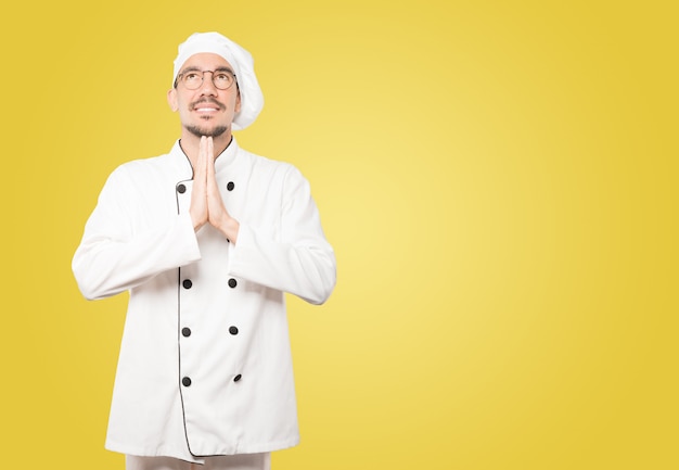 Concerned young chef praying gesture