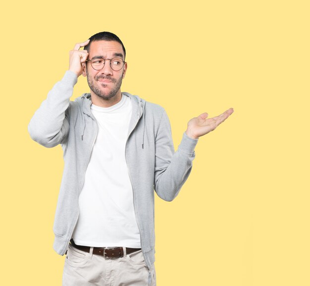 Concerned young man doing a gesture of confusion