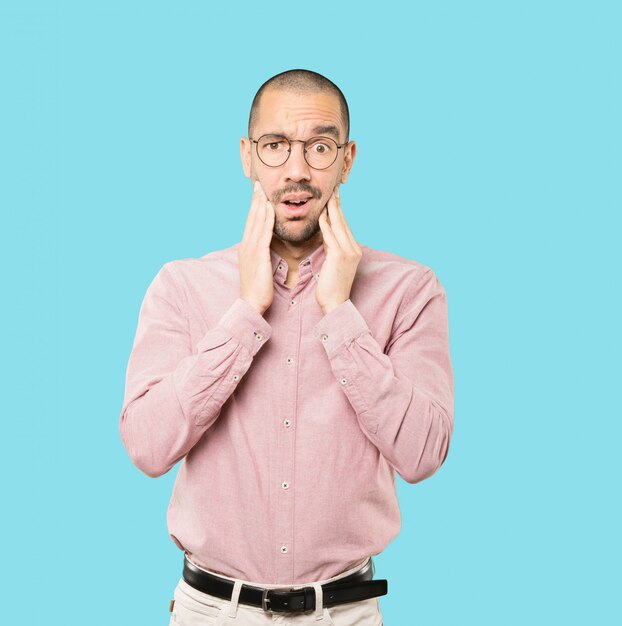 Concerned young man posing against background