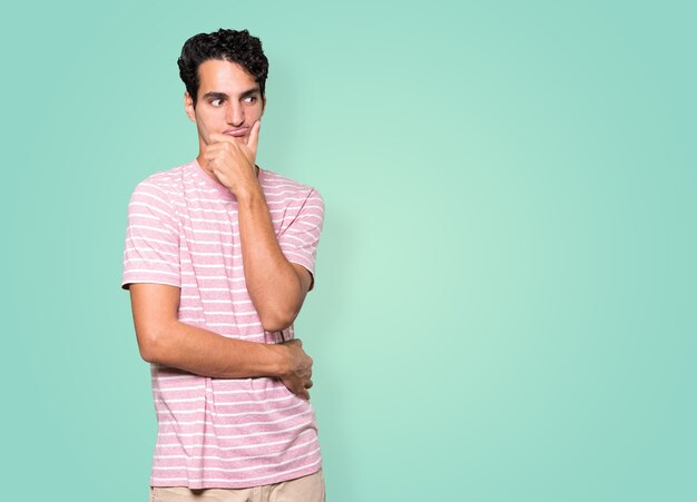 Concerned young man posing against background