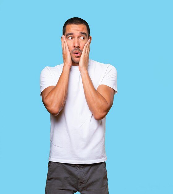 Concerned young man posing against background