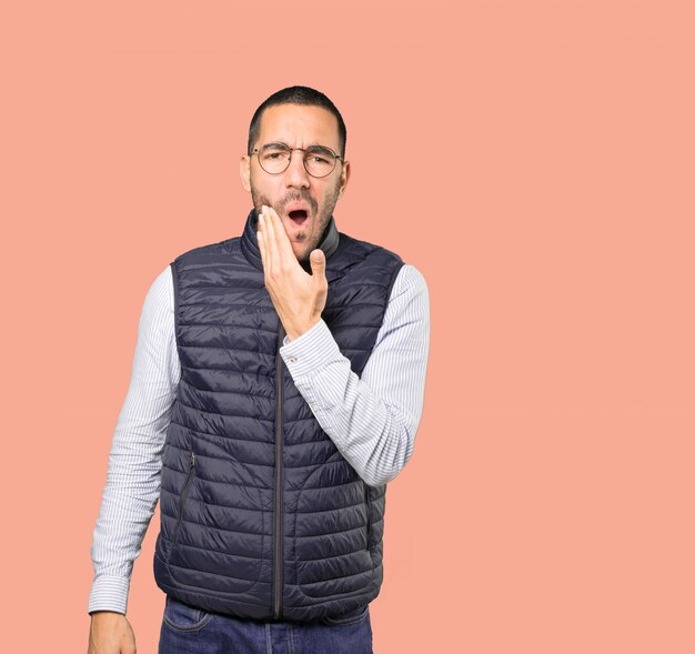 Concerned young man with a toothache gesture