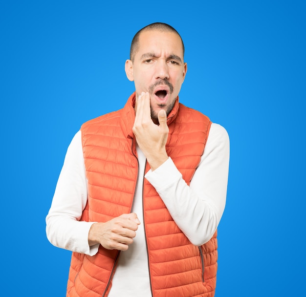 Concerned young man with a toothache gesture