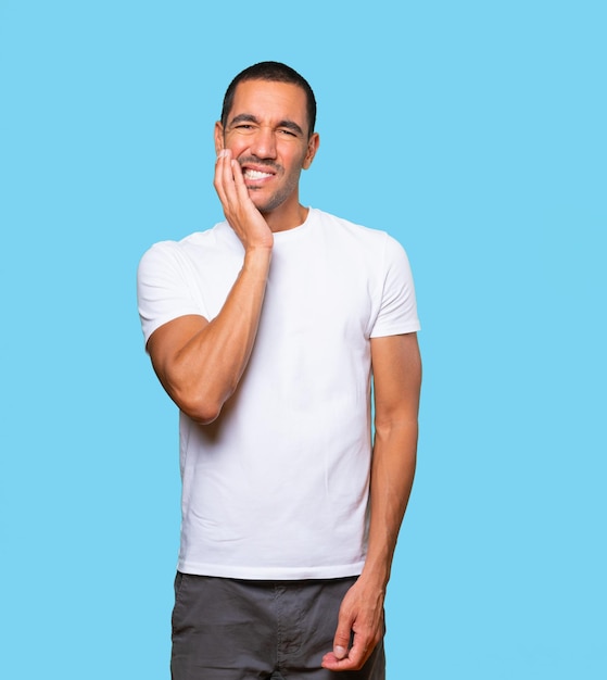 Concerned young man with a toothache gesture