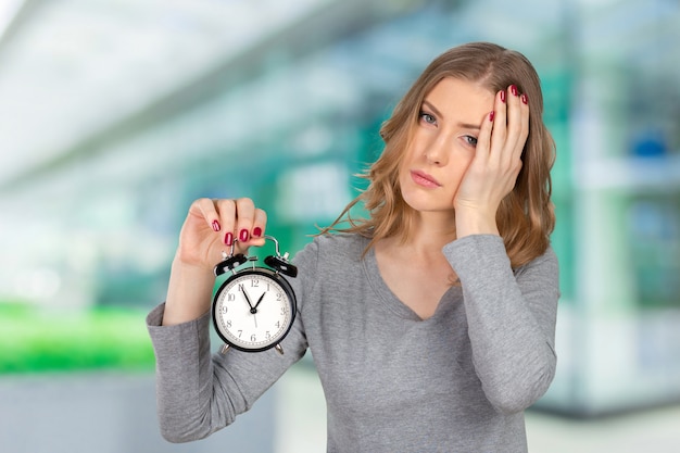 Concerned young woman pointing on clock