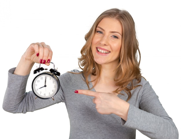 Concerned young woman pointing on clock