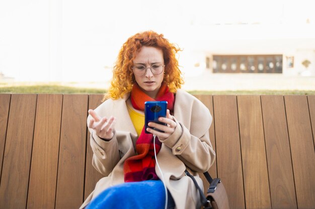 Concerned young woman reading some disturbing news on her smarphone