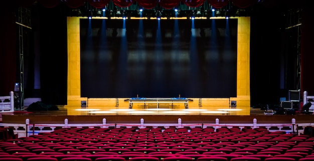 Concert- of voorstellingszaal. Rode stoelen fauteuils en het podium voor concert.