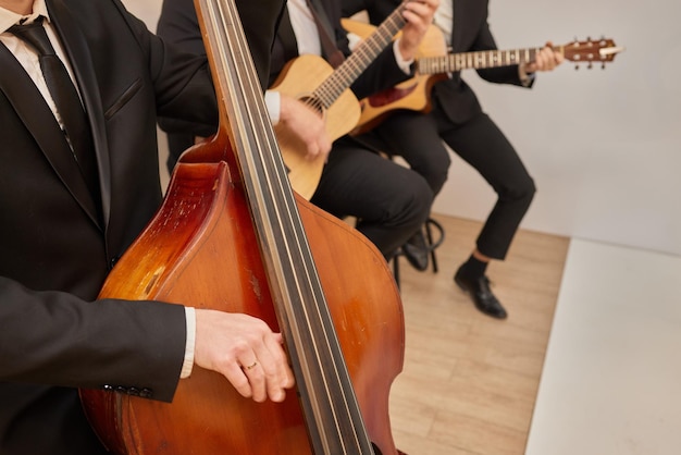 Concert view of a contrabass violoncello player with vocalist and musical band during jazz orchestra band performing music violoncellist cello jazz player on stage