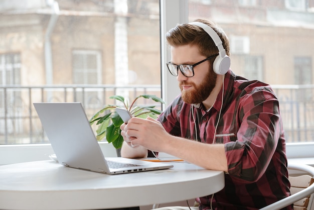 Concetrated young man chatting and listening music.