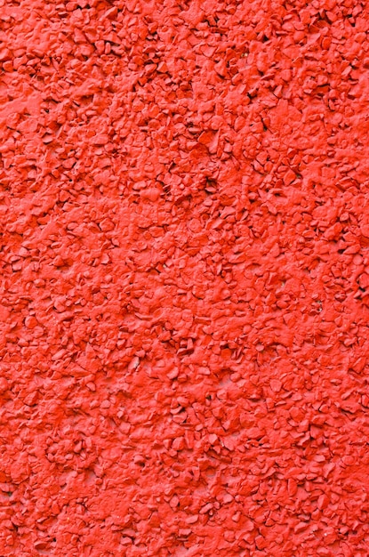 Concrete background painted in red mixed with gravel