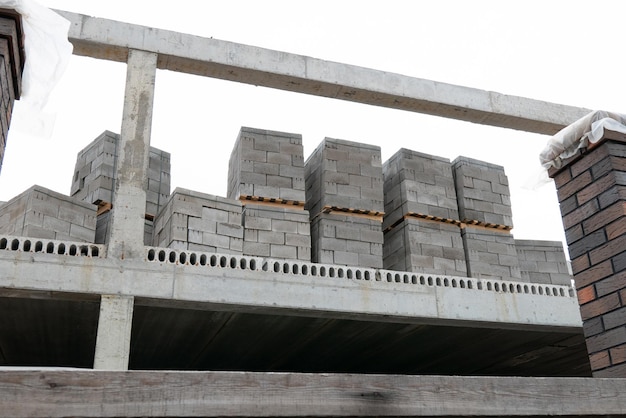 Concrete blocks for construction on wooden pallets are located in an outdoor warehouse closeup