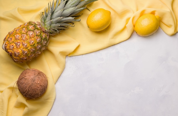 Concrete gray space with yellow cloth and fruits. copy space. summer concept