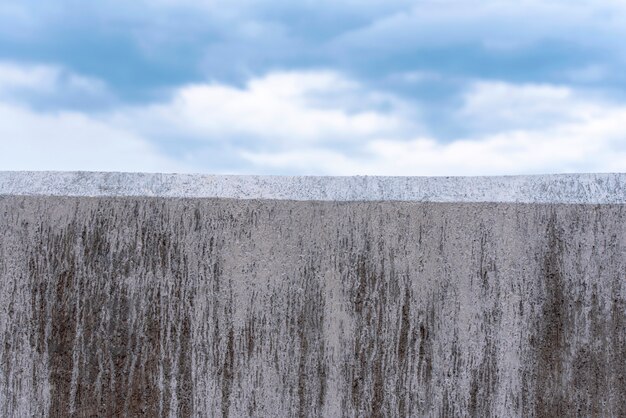 Parete grigia concreta come confine e cielo blu come fondo