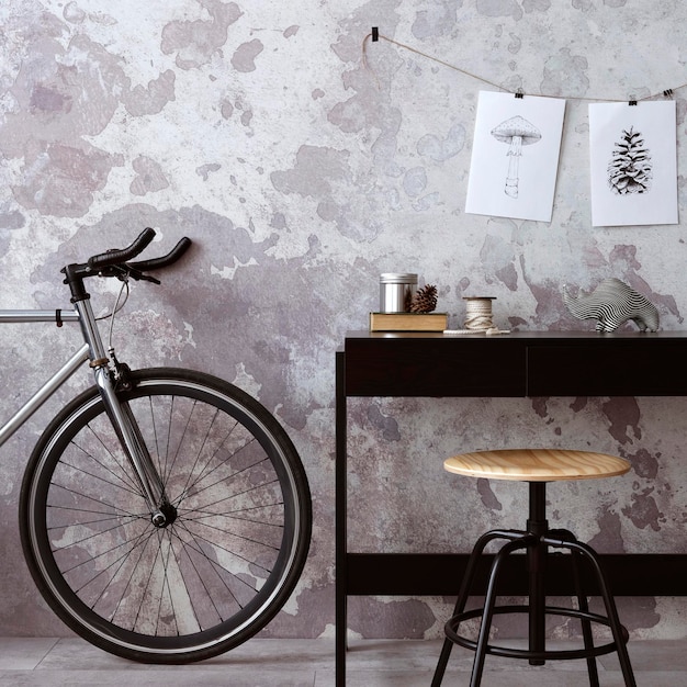 Interno in cemento dell'home office con accessori per ufficio scrivania nera bicicletta rack con accessori personali modello di arredamento per la casa