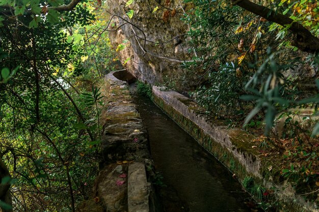 Concrete irrigation canal under the rock in a mountainous area