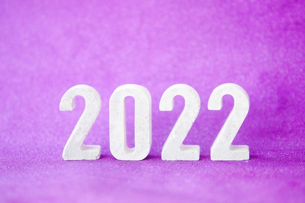 写真 紫色のきらびやかな背景と雪が降るコンクリート番号2022。コピースペース。