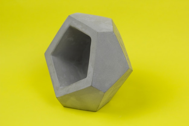 Concrete pot for plants, empty, polygonal shape, bright background