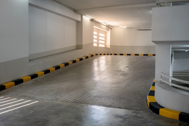 Concrete road and ramp with yellow and black curb in building