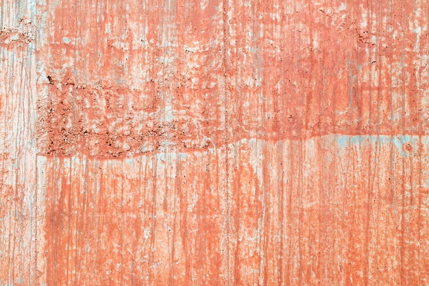 Concrete wall with salmoncolored paint streaks