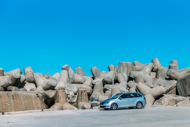 Concrete wave brakers on the coastline with car