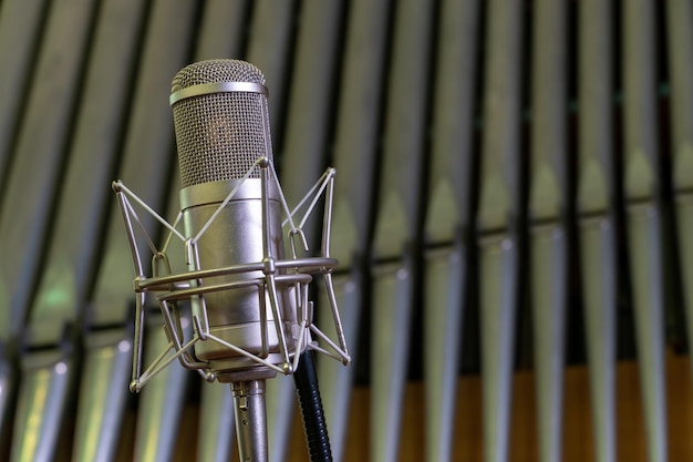 Foto condensatorstudiomicrofoon in een katholieke kerk tegen de achtergrond van orgelpijpen opname van een concert van orgelmuziek professionele geluidsopname