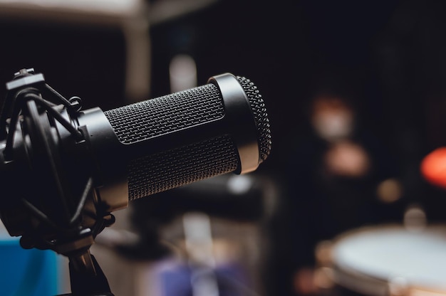 Condenser microphone with a blurred rehearsal room in the background and a copy space to the right