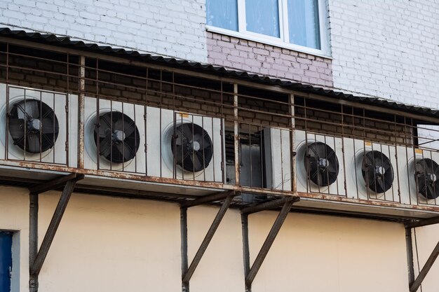 Photo conditioners in row on wall of house