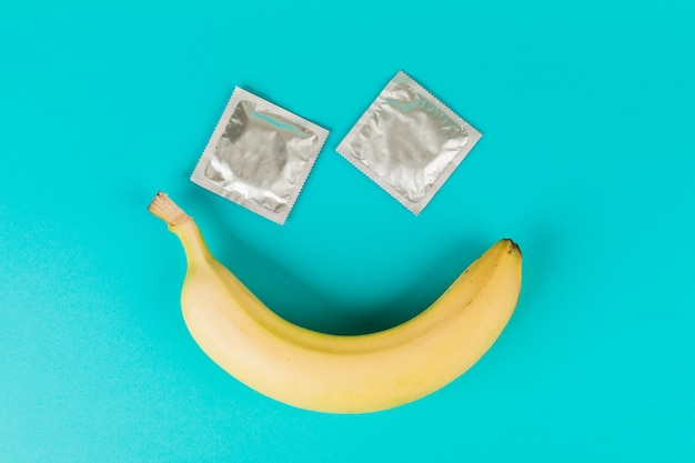 파란색 배경에 콘돔과 바나나 안전한 섹스 섹스 토이 피임