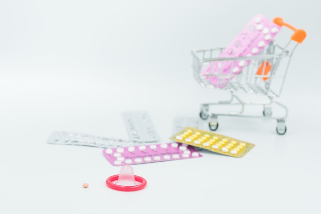 Презервативы и противозачаточные таблетки на белом фоне