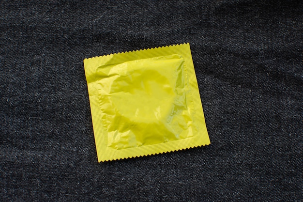 Condom on black jeans pocket with World Aids day concept. 