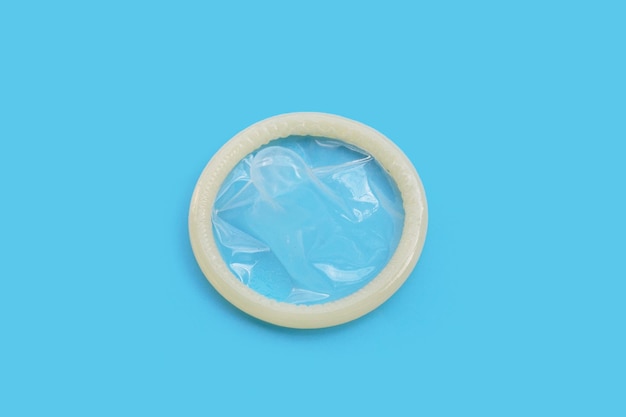 Condom on blue background Copy space