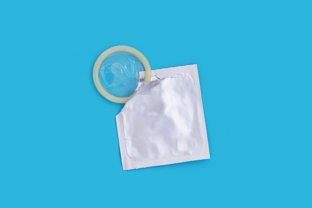 Condom on blue background Copy space